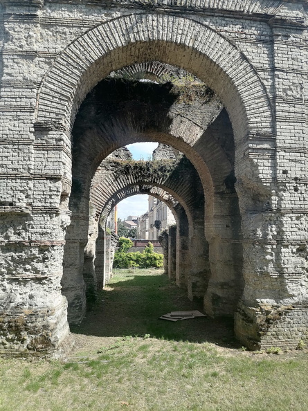 Comme la plupart des amphithéâtres, le Palais Gallien, ultime vestige de Burdigala, se situait en dehors du centre antique de la cité. La ville comptait d’autres monuments dont les fouilles s’emploient encore à retrouver les traces. Ainsi, du temple des « Piliers de Tutelle » détruit en 1677, ne subsiste que le nom d’une rue. Le poète Ausone (309-394), professeur de grammaire et de rhétorique à Burdigala avant de servir Valentinien Ier, a chanté les charmes de la cité (Ordo urbium nobilium, 20).
CC 4.0 Odysseum, photo A. Jayat
Pages à consulter :
Chronologie de l’histoire romaine, glossaire du Musée virtuel
Bordeaux, Palais Gallien, couloir d’accès .jpg