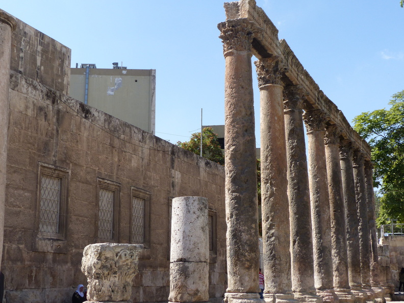 Le forum était bordé de portiques sur trois côtés, tandis que le quatrième côté était marqué par un cours d’eau qui alimentait un nymphée grandiose. Une colonnade d’ordre corinthien, richement décorée, a été partiellement relevée sur le côté sud du forum. Afin d’éviter de se mêler au peuple, les nobles de Philadelphia construisirent un tunnel reliant la citadelle à la partie basse de la ville où se situaient le forum et le théâtre. Mais on en ignore le tracé exact.
CC 4.0 Odysseum, photo F. Poli
Article à consulter : glossaire du Musée virtuel
Amman, colonnade du forum.JPG