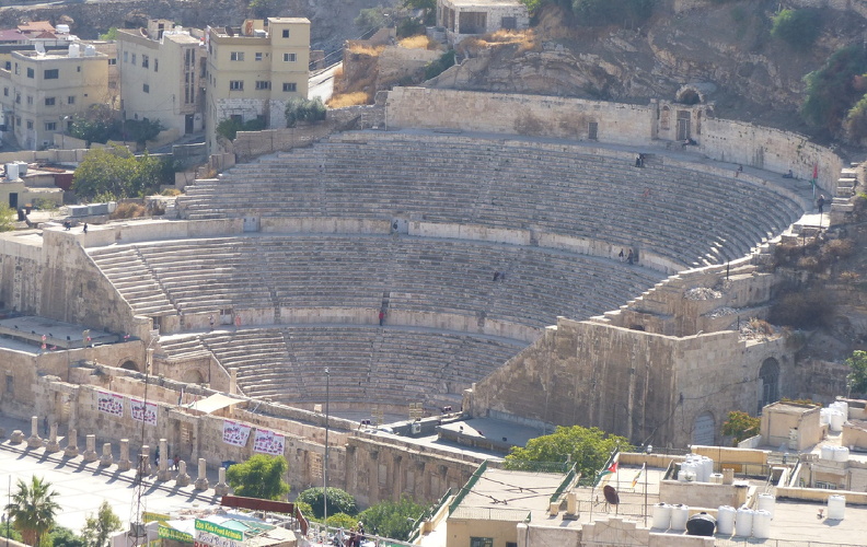 Creusé dans le flanc du jebel El-Taj, le théâtre d’Amman atteint 102 m. de diamètre. Sa cauea est composée de trois rangées de gradins et compte environ 6000 places. Les spectateurs regardent vers le Nord et ne sont donc pas éblouis par le soleil. Les notables installés près de la scène ne se mêlaient pas au peuple assis en hauteur. La petite structure au-dessus du dernier rang de gradins abritait une statue d’Athéna qui occupait une place majeure dans la vie religieuse de la cité.
CC 4.0 Odysseum, photo F. Poli
Articles à consulter : architecture du théâtre - glossaire du Musée virtuel
Amman, le théâtre.JPG