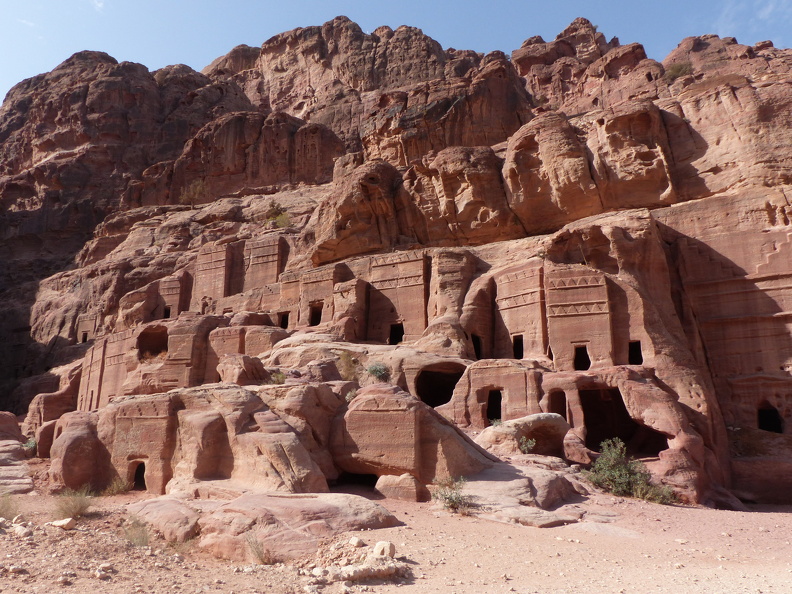 Plus de six-cents tombeaux creusés dans le grès bordent presque toutes les vallées aux alentours de Petra, justifiant la qualification de nécropole. Leur concentration impressionnante a valu à ce secteur le nom de « rue des façades ».Le tombeau-tour apparu au IIe s. av. J.-C. est le type le plus fréquent. Sa façade présente un bloc rectangulaire creusé d’une ouverture et décoré d’une ou deux rangées de merlons à quadruple crénelure que les Nabatéens ont empruntés aux cultures syro-phéniciennes.
CC 4.0 Odysseum, photo F. Poli
Article à consulter :
glossaire du musée virtuel
Petra, tombeaux de « la rue des façades ».JPG