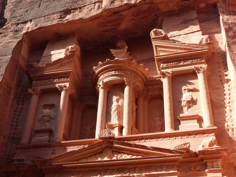 Le niveau supérieur de la Khazneh est plus complexe. La tholos centrale est surmontée d’une urne martelée en vain par les impacts de balles des chasseurs de trésor. La statue d’Isis Fortune qui porte une corne d’abondance et une patère à libations est encadrée par des Amazones qui dansent en tenant une hache au-dessus de leur tête. Si la richesse du décor témoigne de la virtuosité des artisans, les symboles funéraires laissent penser que l’édifice était dédié à une reine ou à un roi nabatéen.
CC 4.0 Odysseum, photo F. Poli
Articles à consulter :
Les Amazones - glossaire du musée virtuel
Petra, niveau supérieur de la Khazneh.JPG