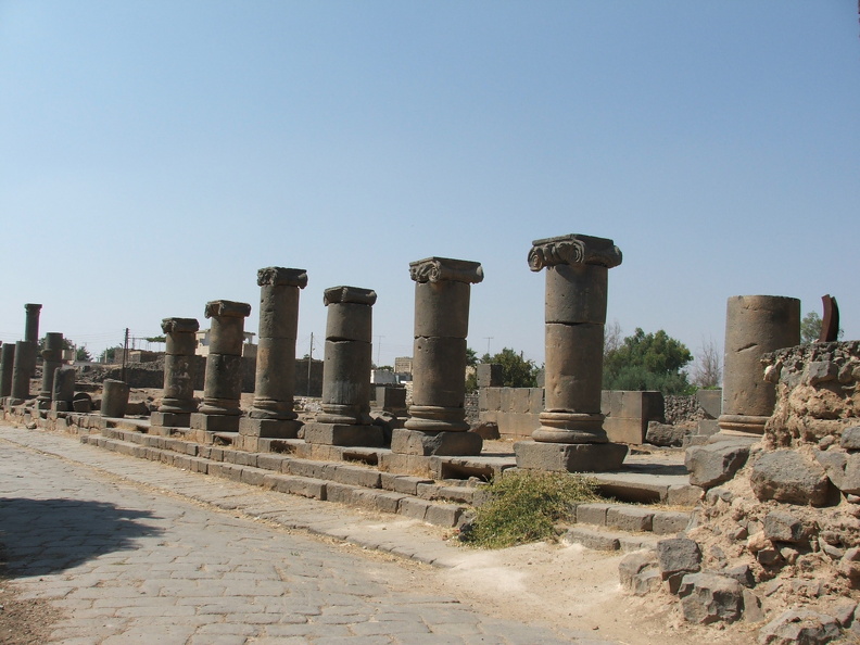 Le commerce de Bosra était prospère. La ville était reliée à la mer Rouge par la Via Noua Troiana. On franchissait les colonnes d’un portique pour rejoindre le macellum (marché), un espace monumental dédié au commerce, construit selon un plan géométrique proche de ceux de Gerasa (Jordanie) et d’Apamée (Syrie). Un cryptoportique de plus de 100 m de long constituait un vaste entrepôt souterrain éclairé par des soupiraux visibles ici entre les bases des colonnes ioniques.
CC 4.0 Odysseum, photo F. Poli
Article à consulter :
Glossaire du musée virtuel
Bosra, portique du macellum.JPG
