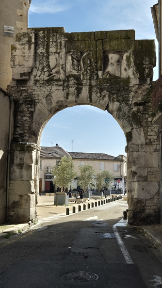 La richesse des monuments à Nîmes est liée à la présence de nombreux gisements calcaires de qualité à proximité. La pierre dure de Baturel a permis d’édifier ce point d’entrée dans Nemausus aujourd’hui appelé porte de France. L’arcade unique surmontée d’une galerie aveugle était pourvue d’un étage supplémentaire et flanquée de deux tours. Il ne subsiste plus que deux portes de l’enceinte romaine longue de 7 km dont la principale fonction était de délimiter la ville de la campagne.
Photos CC 4.0 Odysseum, classe de P. Cochet Terrasson 2025
Article à consulter :
Glossaire du musée
Nîmes, la Porte dite de France.jpg