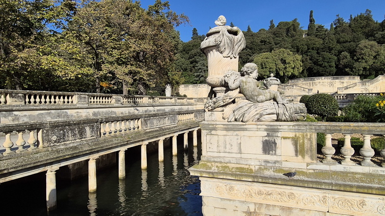 Les actuels Jardins de la Fontaine sont installés à l’emplacement même où les Volques Arécomiques rendaient un culte au dieu celte Nemausos. Au Ier s. ap. J.-C., on y a édifié un Augusteum dédié au culte de la famille impériale. Des propylées en marquaient l’entrée ; un nymphée consacrait la source et un autel voué au culte impérial se dressait au centre d’une plateforme ornée de colonnes libres à chaque angle. À proximité se trouvaient des thermes alimentés par l’aqueduc ainsi qu’un théâtre.
Photos CC 4.0 Odysseum, classe de P. Cochet Terrasson 2025
Articles à consulter :
Les Romains et l’eau - Glossaire du musée virtuel
Nîmes, les Jardins de la Fontaine.jpg