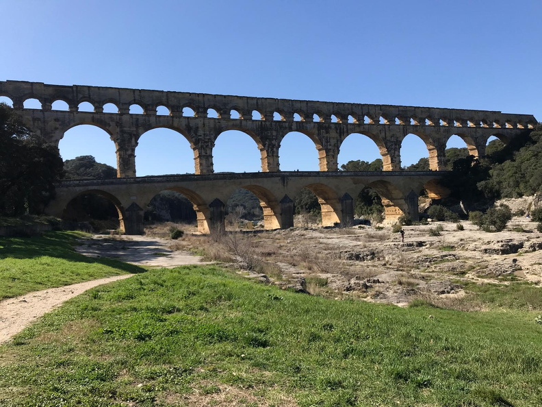 Le Pont du Gard est l’une des dix-sept infrastructures aériennes d’un aqueduc long de 50 km et qui acheminait l’eau d’Uzès jusqu’à la ville de Nemausus (Nîmes). Construit au Ier s. ap. J.-C., il permit de répondre aux besoins en eau de la cité en plein essor. Constitué de trois arches superposées, c’est le plus haut pont romain connu puisqu’il s’élève à 49 m et mesure 490 m de long. Véritable prouesse technique d’un poids total évalué à 50 000 tonnes, il enjambe le Gardon large de 25 m.
Photos CC 4.0 Odysseum, classe de P. Cochet Terrasson 2025
Articles à consulter :
Le Pont du Gard - Glossaire du musée virtuel
Pont du Gard le Pont du Gard.jpg